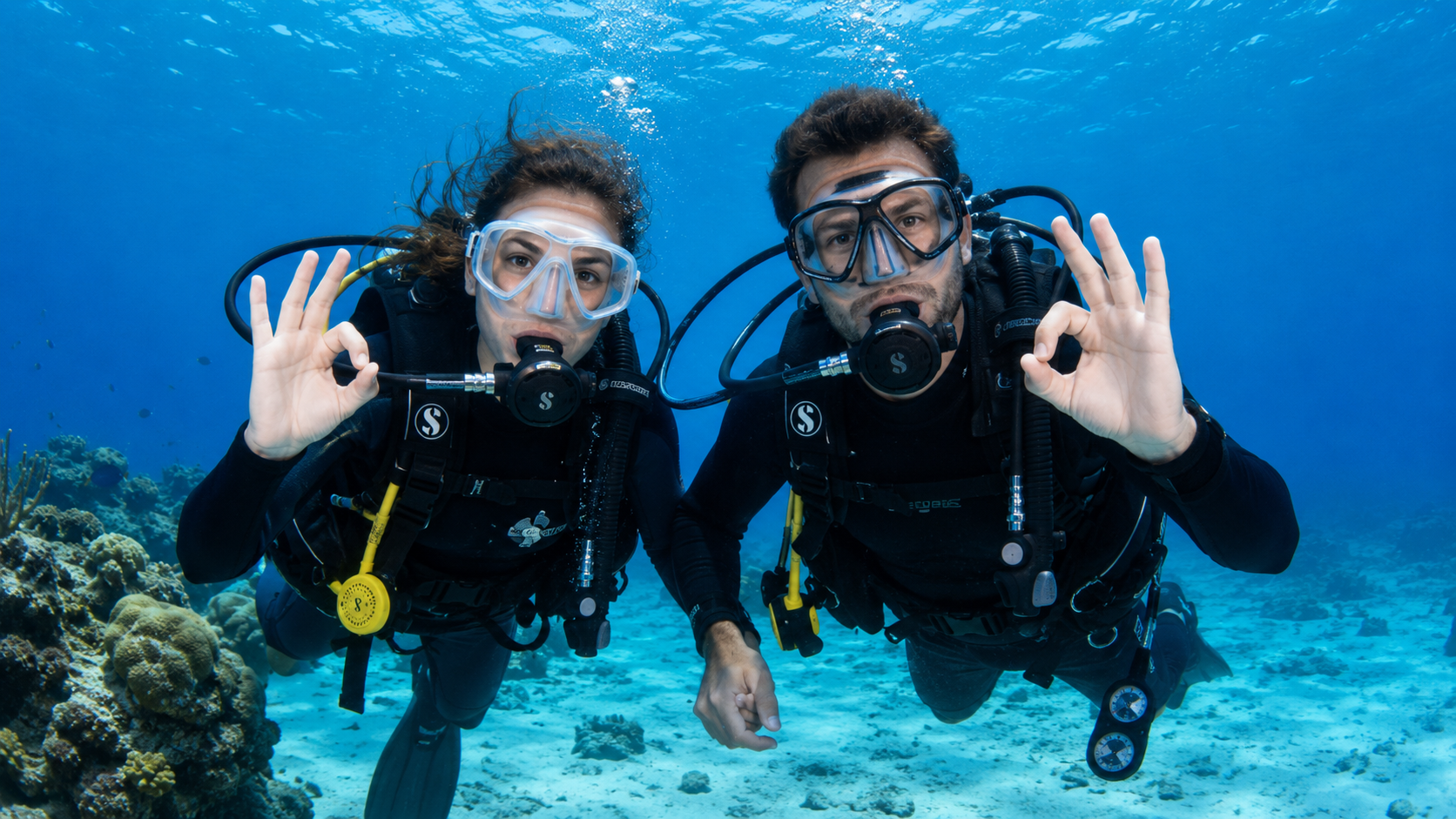 Certified scuba divers practicing safe diving procedures in clear Cozumel water