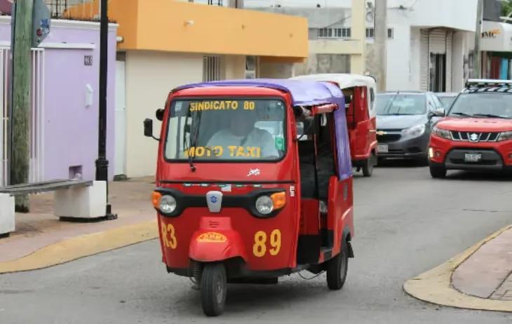 Red moto-taxi number 89 driving through a downtown Cozumel street