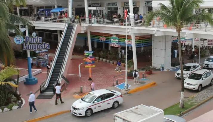 White Cozumel taxi passing the Punta Langosta cruise pier entrance and signpost