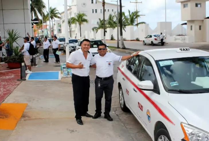 Two uniformed Cozumel taxi drivers standing beside their cab