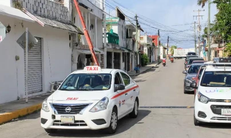White Cozumel taxi driving along a residential street in downtown San Miguel