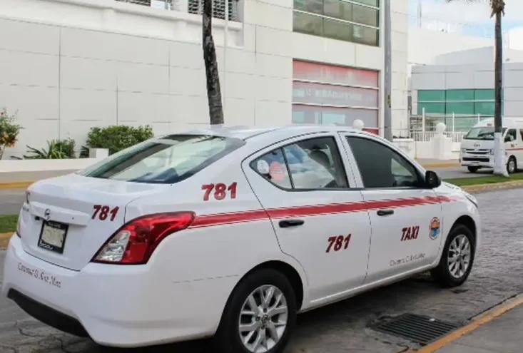 Rear view of white Cozumel taxi number 781 showing the red stripe and roof sign