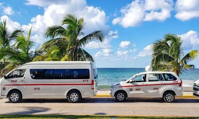 Cozumel taxi van and taxi sedan parked together on the coastal road by the sea