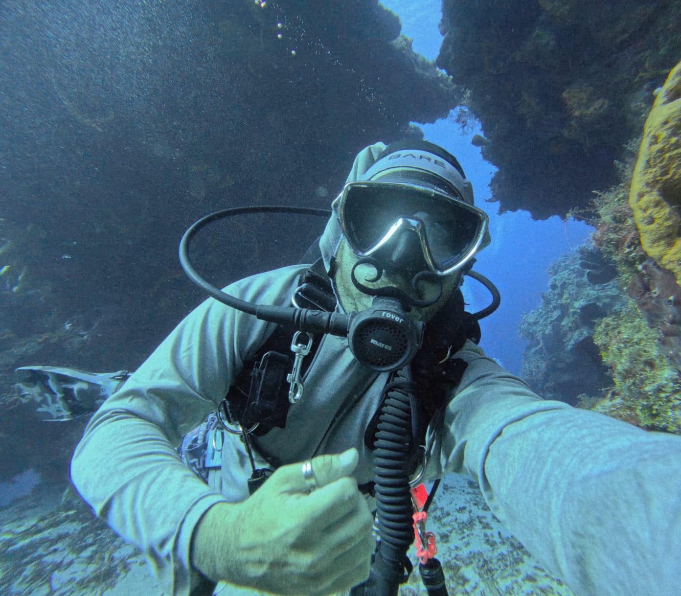 Luis Sifuentes Marín, PADI dive instructor in Cozumel, diving beside a reef wall